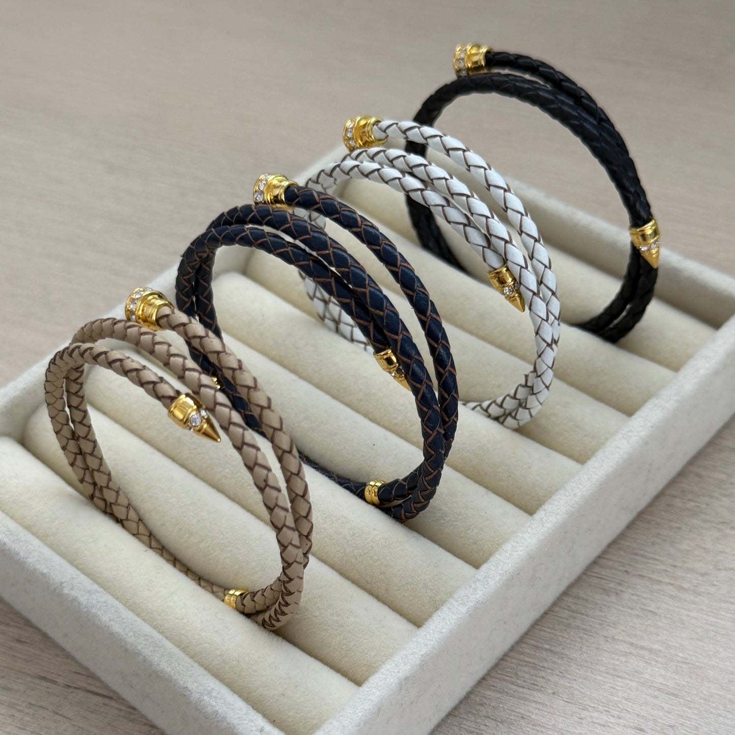 Set of braided hair ties on a white display stand with a neutral background