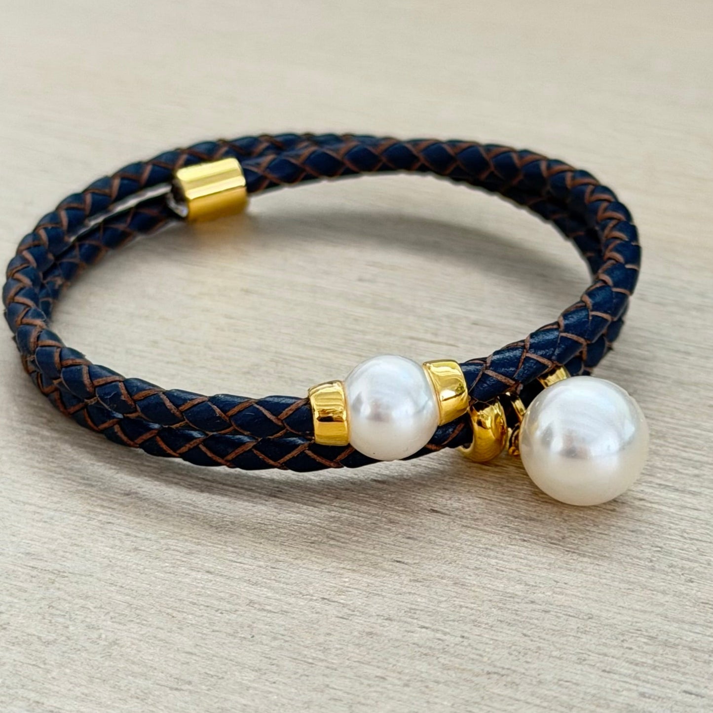 Bracelet with pearls and gold accents on a beige surface